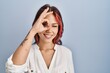 © Krakenimages.com - Young caucasian woman wearing casual white shirt over isolated background doing ok gesture with hand smiling, eye looking through fingers with happy face.