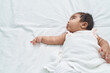 © Krakenimages.com - African american baby lying on bed with relaxed expression at bedroom
