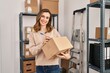© Krakenimages.com - Young woman ecommerce business worker writing on package at office