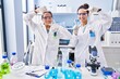 © Krakenimages.com - Young mother and daughter at scientist laboratory smiling making frame with hands and fingers with happy face. creativity and photography concept.