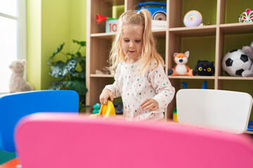 Sticker - Adorable blonde girl preschool student smiling confident opening backpack at kindergarten