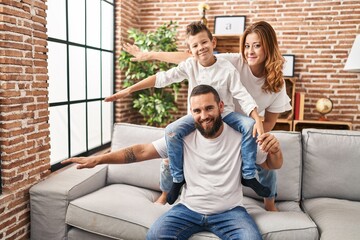 Wall Mural - Family smiling confident playing sitting on sofa at home