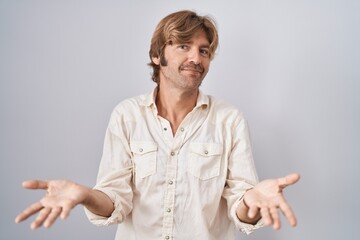 Canvas Print - Middle age man standing over isolated background clueless and confused with open arms, no idea concept.