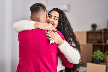 Poster - Man and woman couple hugging each other holding key at new home