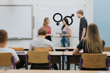 Fototapeta Przestrzenne - Young teacher is standing in front of the blackboard during sex education lesson
