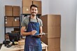 © Krakenimages.com - Young hispanic man business worker writing on clipboard at storehouse