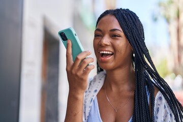 Sticker - African american woman smiling confident talking on the smartphone at street