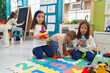 © Krakenimages.com - Group of kids playing with hoops toys sitting on floor at kindergarten