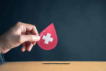 Wall Mural - hands drop blood paper cut to donation box, blood transfusion, world blood donor day, red cross to give blood.world hemophilia day concept