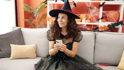 Poster - Middle age hispanic woman using smartphone having halloween party at home