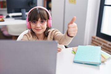 Poster - Adorable hispanic girl student using laptop and headphones doing ok gesture at classroom