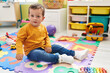 © Krakenimages.com - Adorable caucasian boy playing xylophone sitting on floor at kindergarten