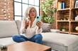 © Krakenimages.com - Middle age woman using smartphone holding pills at home