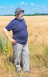 Portrait of elderly Ukrainian senior wearing hat  while standing in wheat   field