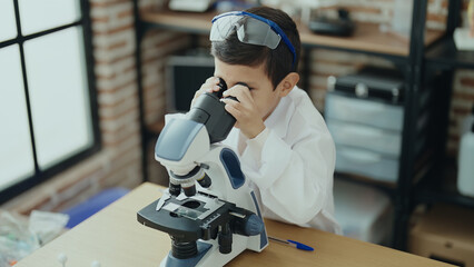 Canvas Print - Adorable hispanic boy student using microscope at laboratory classroom