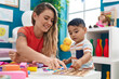 © Krakenimages.com - Teacher and toddler playing with maths puzzle game sitting on table at kindergarten