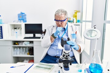 Canvas Print - Senior caucasian man working at scientist laboratory feeling unwell and coughing as symptom for cold or bronchitis. health care concept.