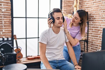 Wall Mural - Man and woman musicians listening to music composing song at music studio