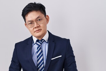 Sticker - Young asian man wearing business suit and tie looking sleepy and tired, exhausted for fatigue and hangover, lazy eyes in the morning.