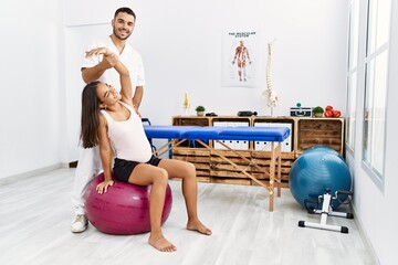 Sticker - Latin man and woman wearing physiotherapist uniform having pregnancy rehab session using fit ball at physiotherapy clinic