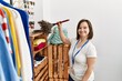 Brunette woman with down syndrome working as shop assistant cleaning dust at retail shop
