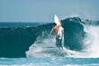 © Barry - A surfer carves a radical off-the-lip on a beautiful blue wave in the ocean.