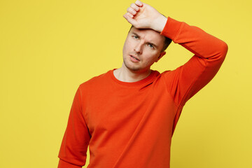 Wall Mural - Young sad sick ill tired caucasian man wearing orange casual clothes put hand on forehead suffering from headache isolated on plain yellow color background studio portrait. People lifestyle concept.