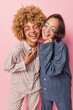 © WHstudio Leushin N - Overjoyed multiracial women laugh happily keep eyes closed stand with closed eyes dressed in nightwear undergo beauty procedures at home isolated over pink background stand closely to each other