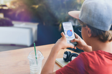 Young boy reading emails on smartphone. Phone in hands. Community social media communication concept