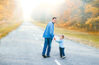 © Kostia - A Happy parent with child are walking along the road in the park on nature travel