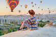 © Goffkein - Man traveler vacations beautiful destination in Goreme, Turkey. Fabulous Kapadokya with flying air balloons at sunrise, Anatolia