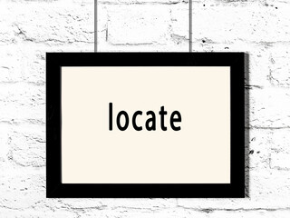 Wall Mural - Black frame hanging on white brick wall with inscription locate