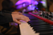 Hands Of A Person Playing The Piano With Defocused Background