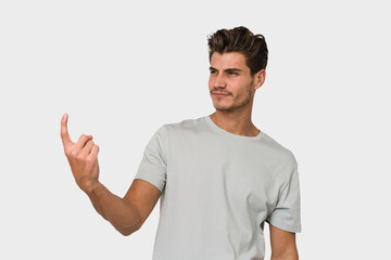 Young handsome caucasian man isolated on white background pointing with finger at you as if inviting come closer.