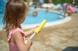 © justoomm - Small child joyfully splashing water in the pool in summer