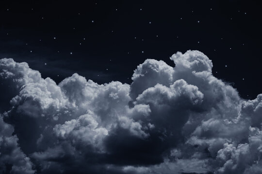Wall Mural -  - Black dark blue night sky with stars. White cumulus clouds. Moonlight, starlight. Background for design. Astrology, astronomy, science fiction, fantasy, dream. Storm front. Dramatic.