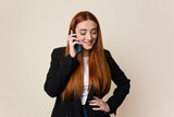 Fototapeta Konie - Young red hair business woman using her mobile phone isolated