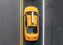 Overhead View Of Yellow New York City Taxi Driving Between The Lines On The Road