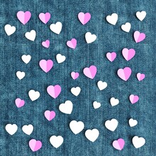 Folded Paper Hearts Scattered On Denim Fabric Background