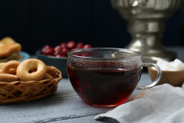 Wall Mural - Glass cup of aromatic tea on light blue wooden table