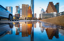 Vibrant Austin Texas City Skyline And Modern Buildings Reflected On The Rainwater Over The Congress Avenue Bridge Over The Lady Bird Lake In The Capital Of Texas, USA