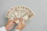 Fototapeta  - man hand holding Japanese Yen banknote stack. Thousand Yen money. Japan cash, Tax, Recession Economy, Inflation, Investment, finance and shopping payment concepts