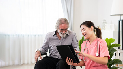 Young professional confident skilled woman doctor visiting Caucasian senior patient man at home for treatment control care giving. Nurse talking to senior patient and using tablet. Healthcare concept