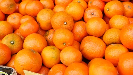 Wall Mural - Fresh ripe mandarins on the counter in supermarket, puts out for sale. Close-up image. High quality 4k footage