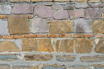 Wall Mural - wall background with texture of cut stones inserted into concrete masonry. the wall in front of the house is decorative