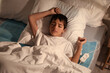 © Pixel-Shot - Little boy sleeping on electric heating pad in bedroom at night, top view