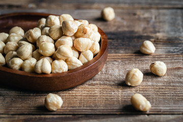 Sticker - Heap of roasted hazelnuts close-up on a wooden background.