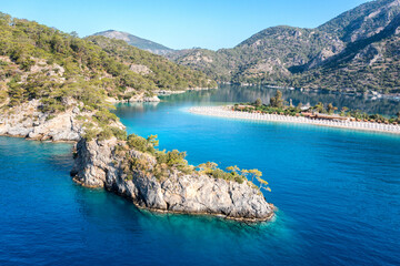 Fototapete - Turkey, scenic beach with white sand surrounded blue sea. Amazing aerial view on sea coast. Blue lagoon lost surrounded between high moutains. Sunny day in small town Oludeniz, Turkey. 