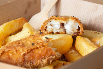 Wall Mural - Fish and chips takeaway in a cardboard tray with a wooden fork. Biodegradable plastic free eco friendly takeaway container