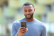 © Antonioguillem - Serious black man using cellphone in the street